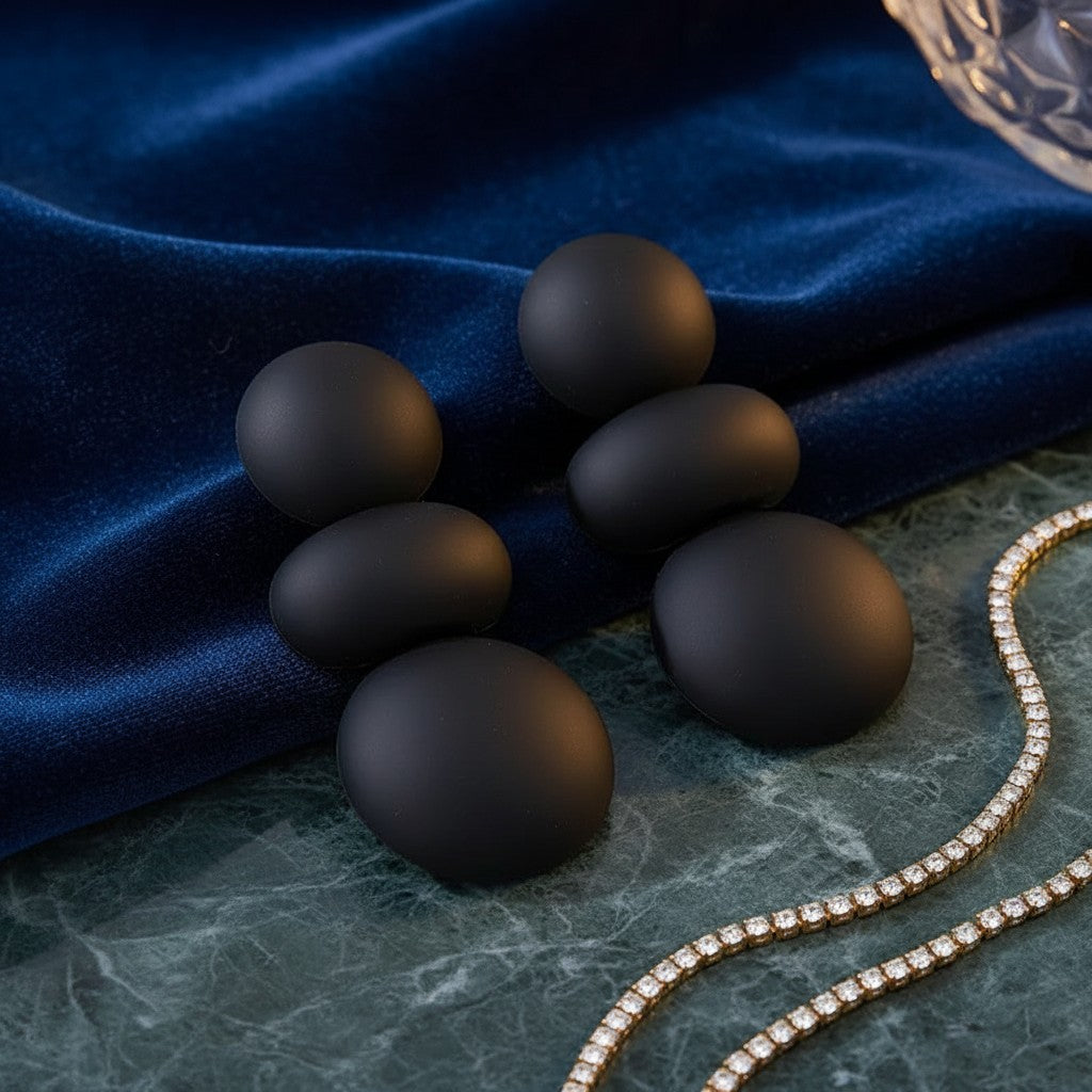 House of eLLe I'm Flexible matte black statement earrings featuring stacked round beads on blue velvet fabric.