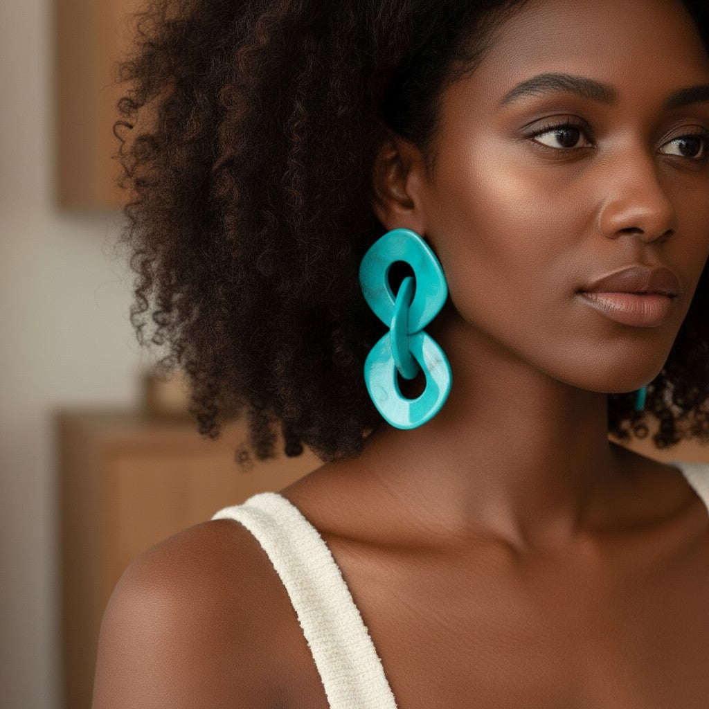 House of eLLe teal abstract link earrings with a polished finish. Model wears a white tank top.