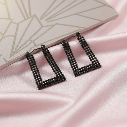 House of eLLe Always A Vibe rectangular hoop earrings in black with pavé crystal detailing on pink satin fabric.