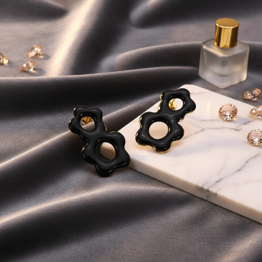 House of eLLe Flow Vibes earrings in black stainless steel with a unique organic flower shape on a marble display