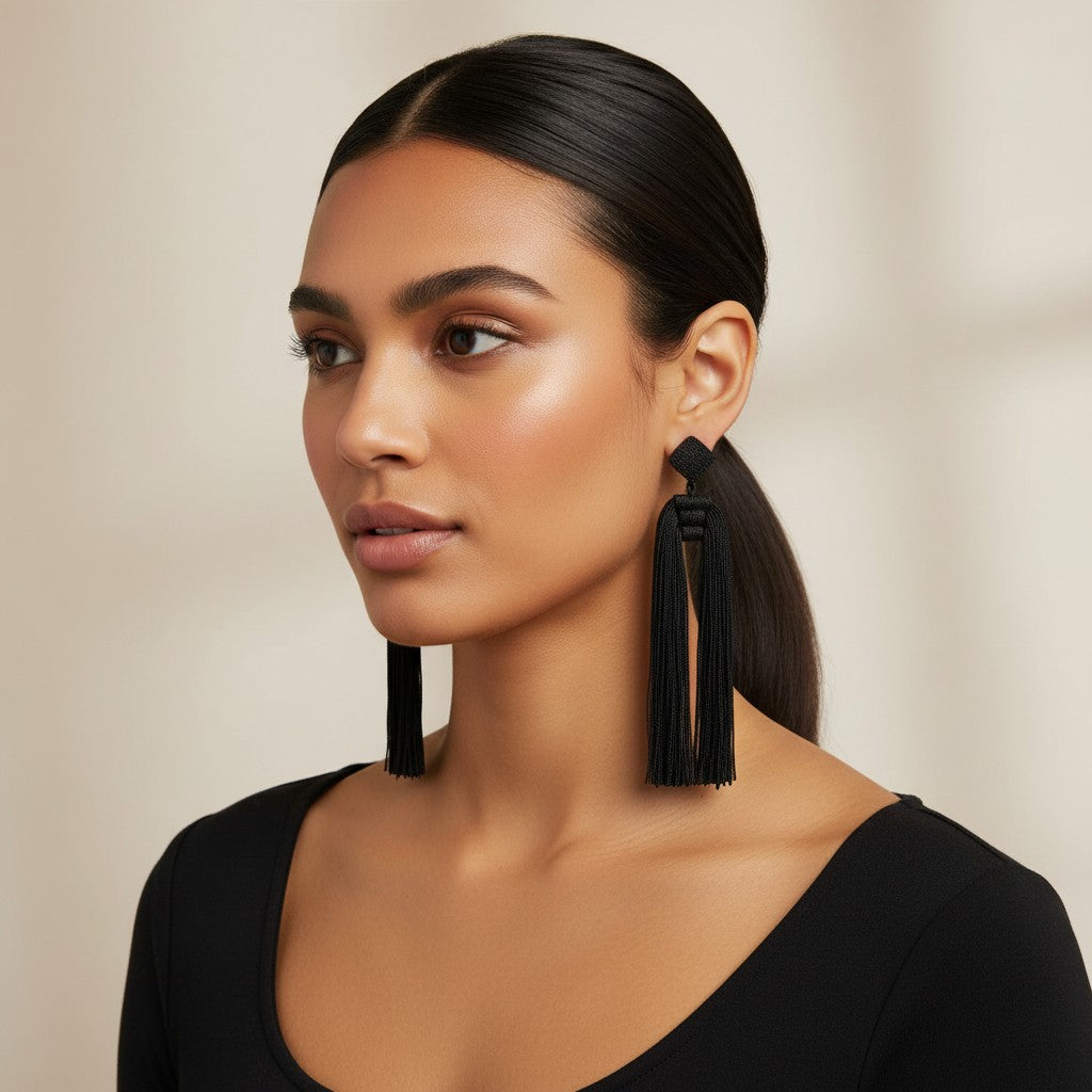 Model wearing House of eLLe Queen Era black tassel earrings with a square stud top against a neutral background.