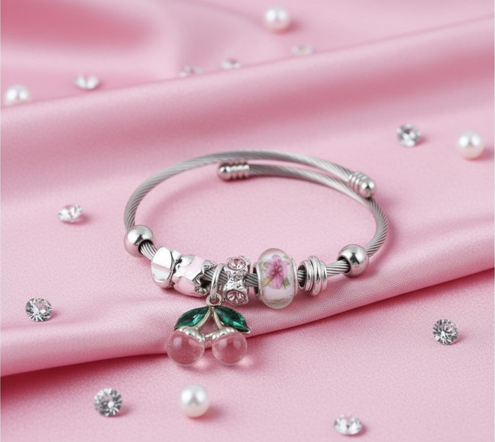 House of eLLe Cherries On Top bracelet featuring a silver cable band with pink cherry charms and floral beads.