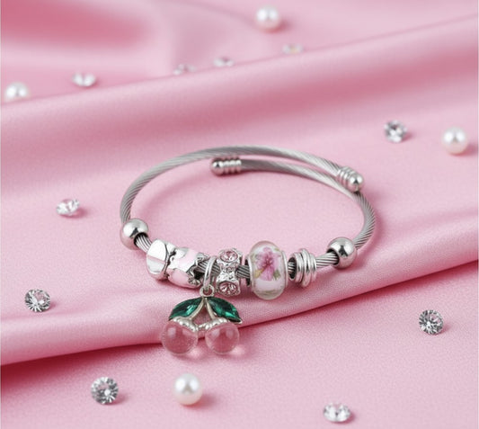 House of eLLe Cherries On Top bracelet featuring a silver cable band with pink cherry charms and floral beads.