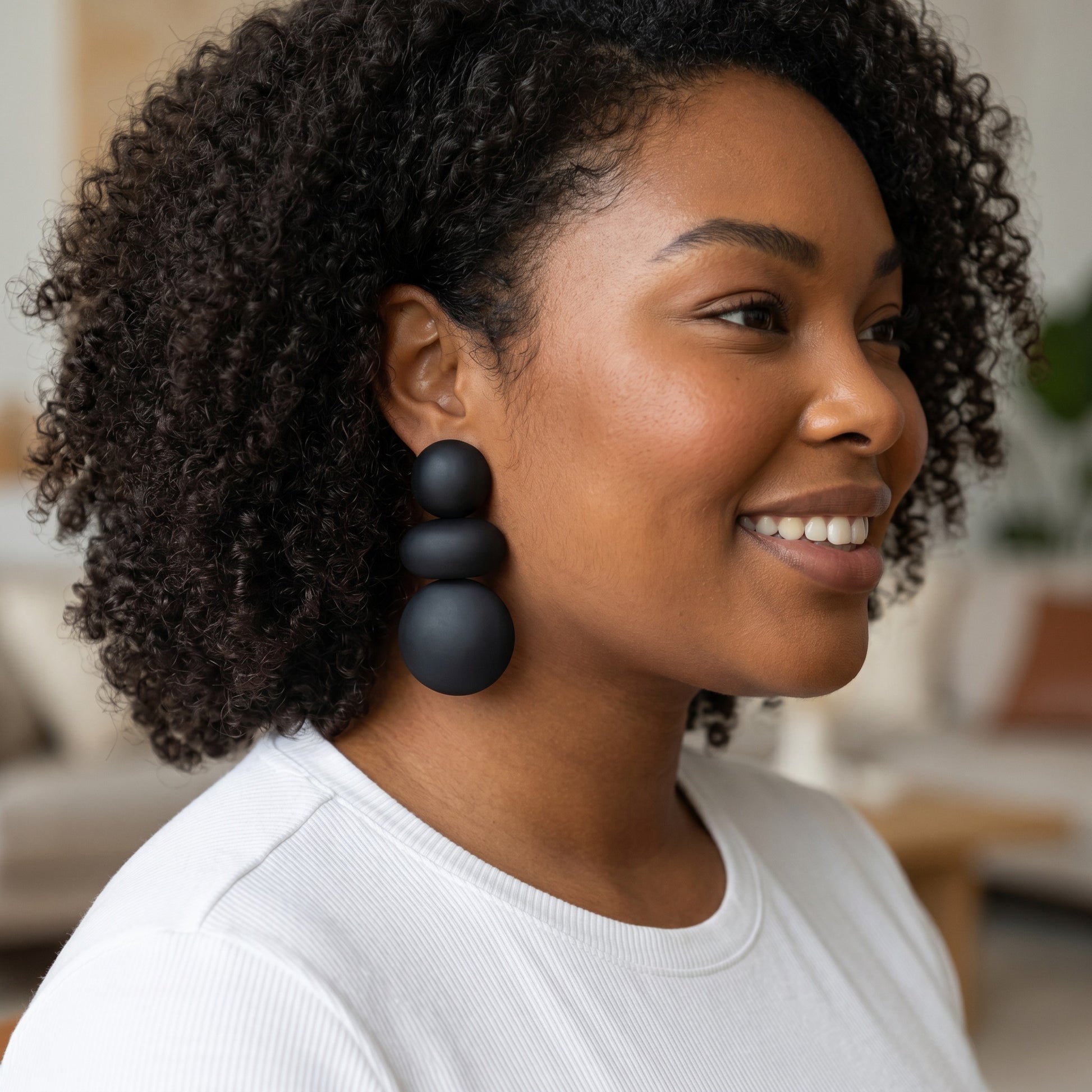 Model wearing House of eLLe I'm Flexible black statement earrings featuring three stacked matte spherical beads.