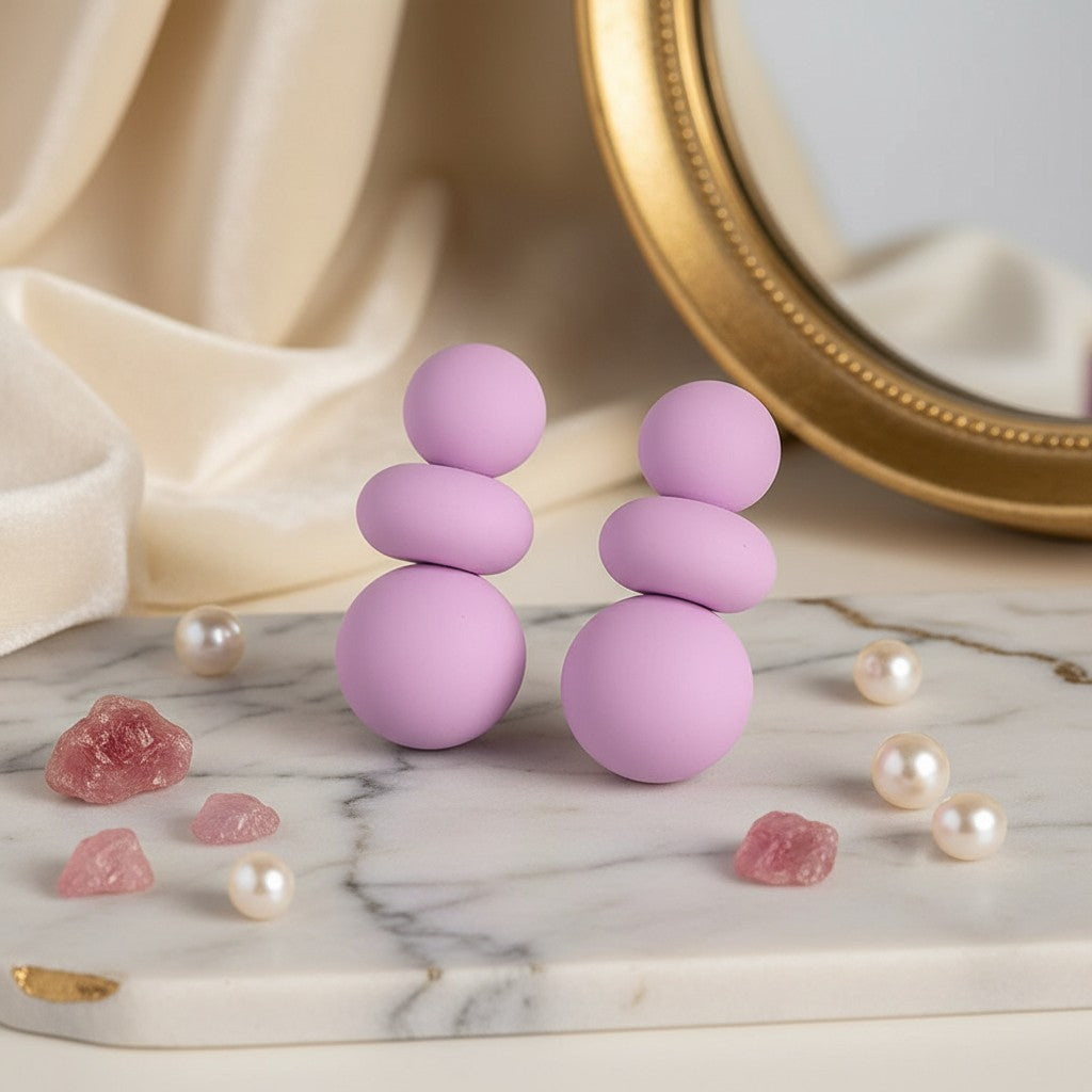House of eLLe I'm Flexible purple matte finish stacked ball earrings displayed on a marble surface with pearls.