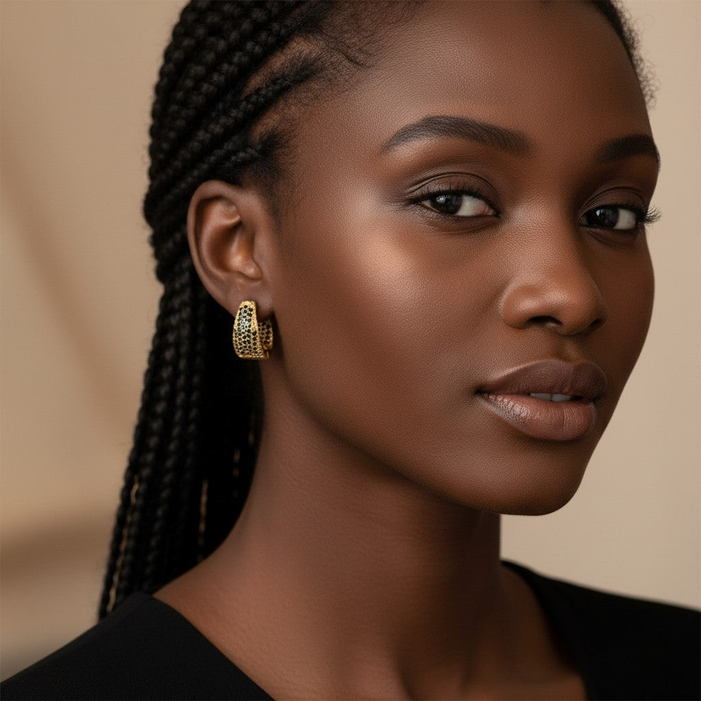 Model wearing House of eLLe Dipped In Bling gold hoop earrings featuring black diamond pavé accents.