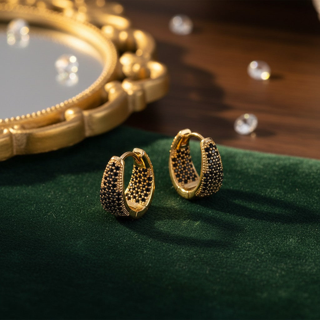 House of eLLe Dipped In Bling hoop earrings featuring gold metal and pavé-set black diamonds on green velvet