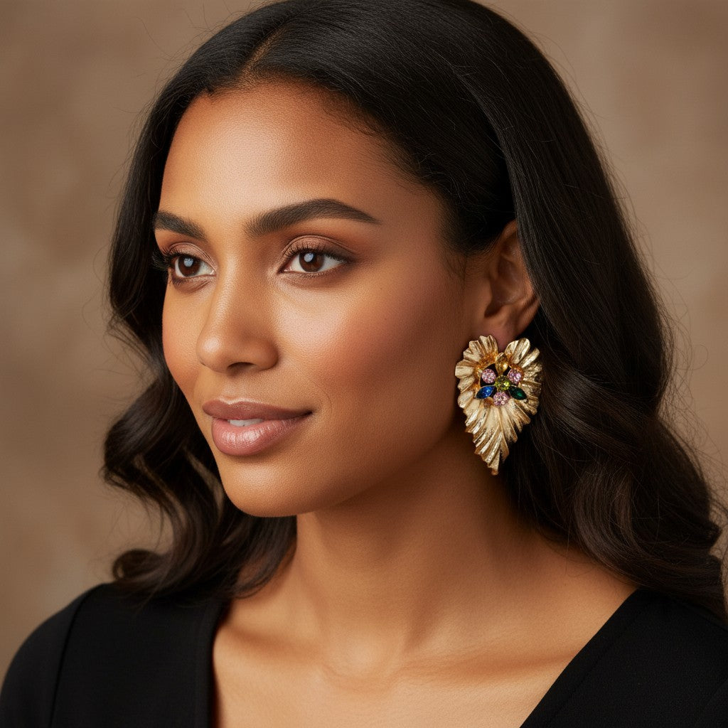 House of eLLe gold-tone textured leaf-shaped cluster earrings with colorful gemstones worn by a woman.