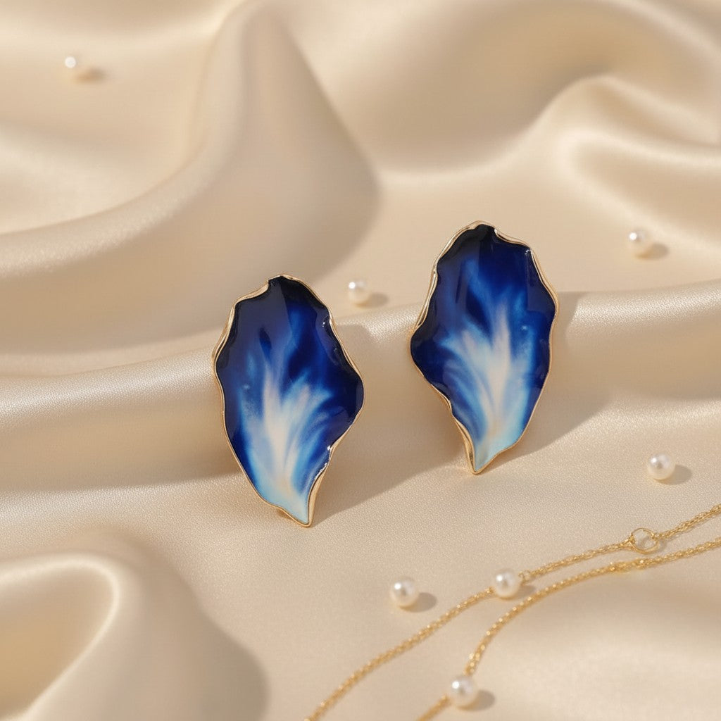 House of eLLe Beautiful Me earrings featuring organic leaf-shaped enamel in gradient blue and white on silk fabric.