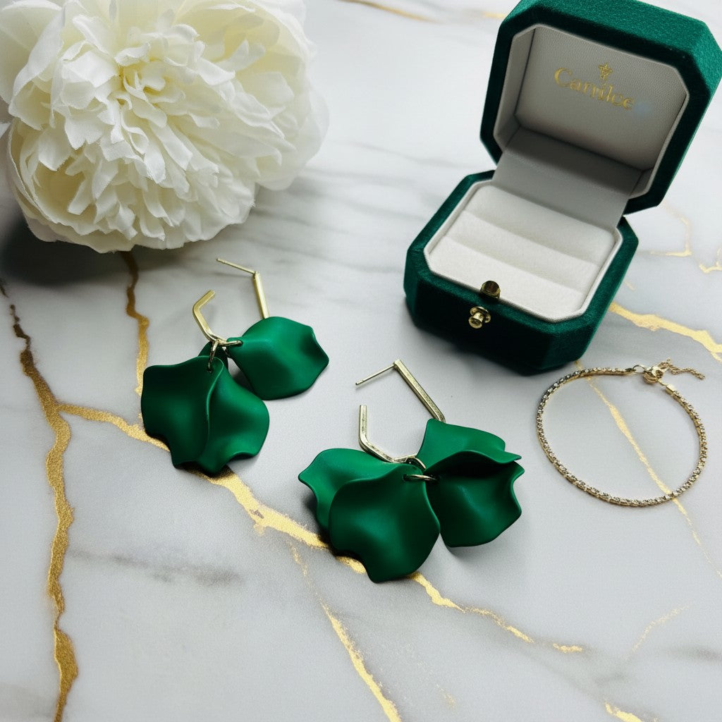 House of eLLe Mini Falling For You green acrylic petal drop earrings with gold-tone hardware on a marble surface.
