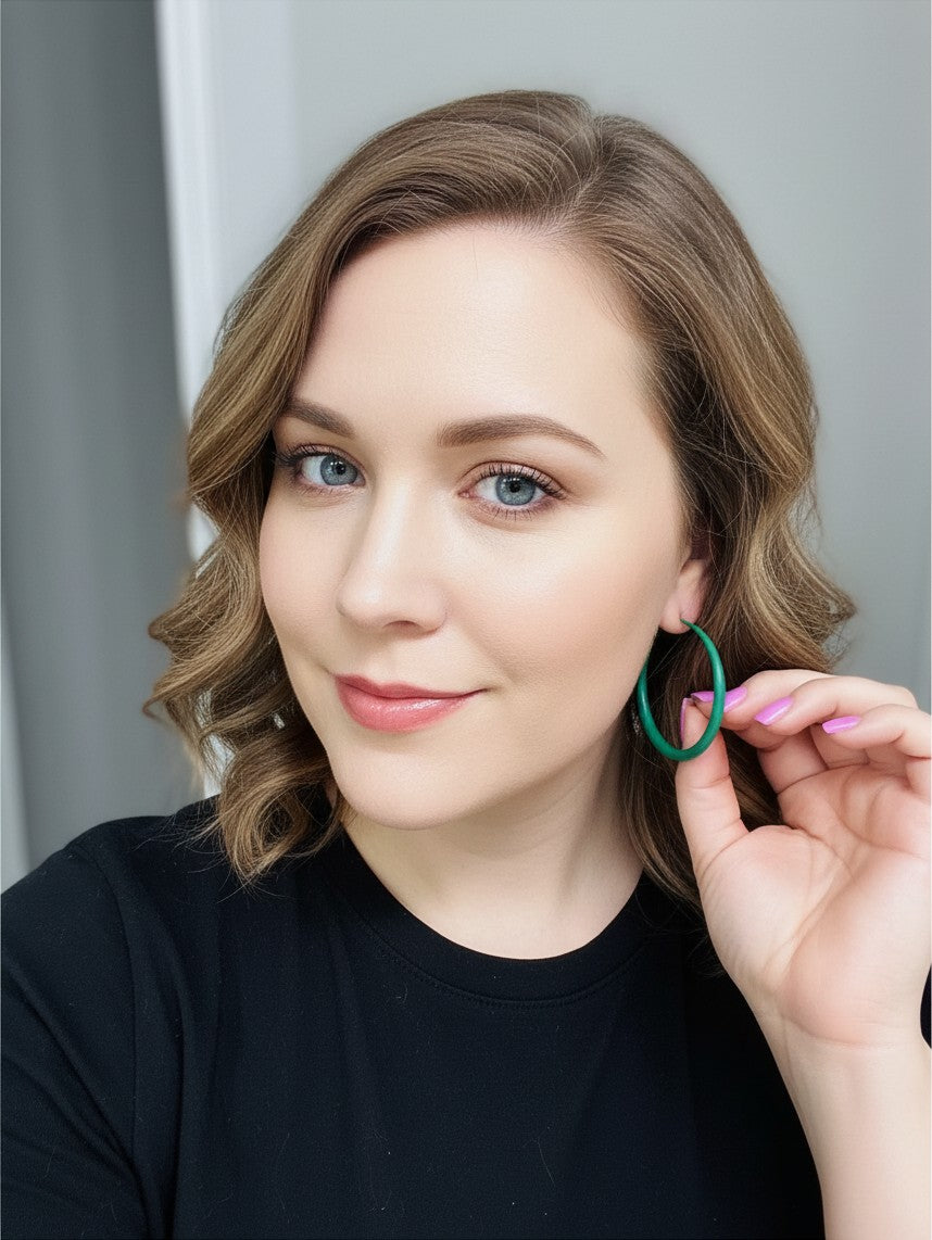 Woman wearing House of eLLe Lucky Green Hoops, a pair of vibrant green circular hoop earrings.