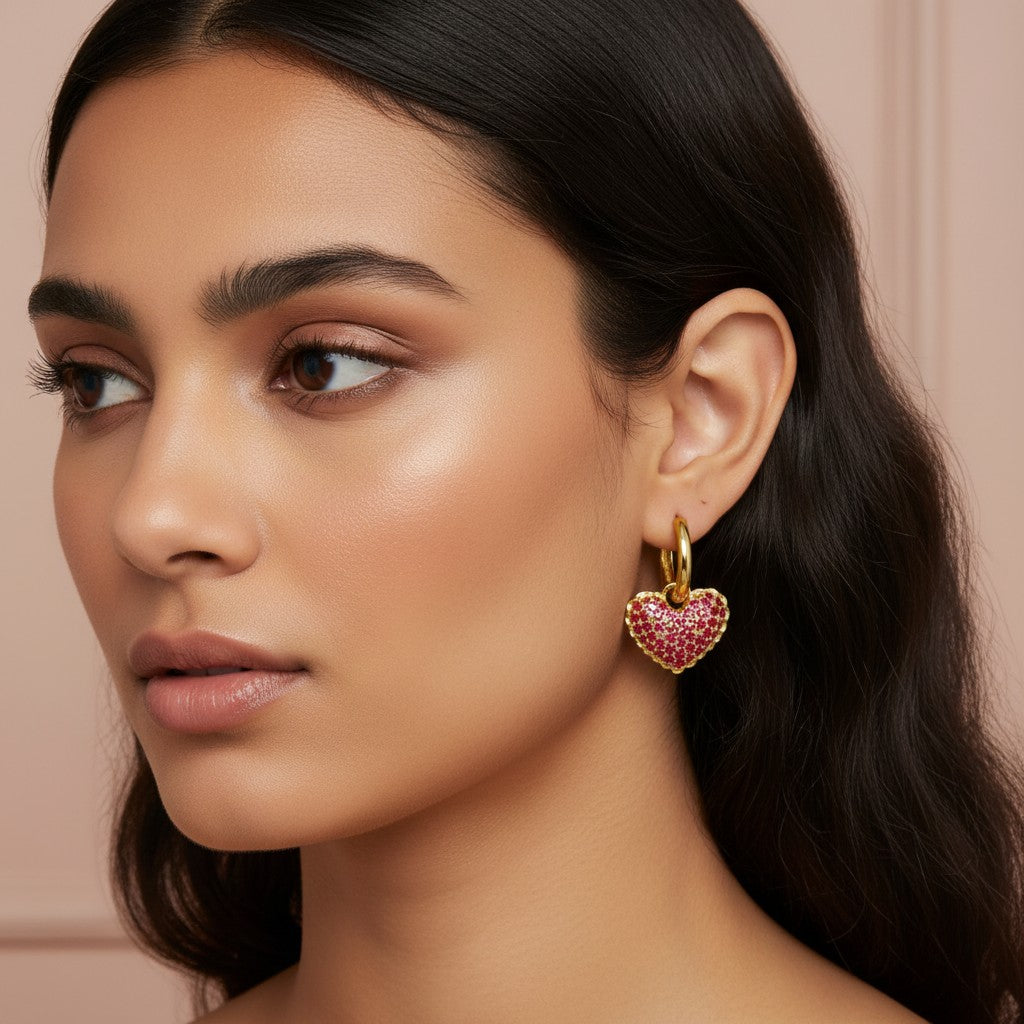 Model wearing House of eLLe 18K gold plated mini heart earrings with pink crystal embellishments
