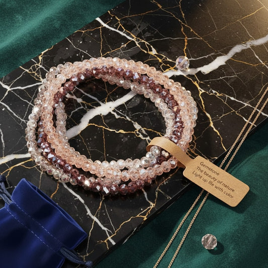 House of eLLe pink and purple faceted glass beaded stretch bracelet set on a black marble display board.