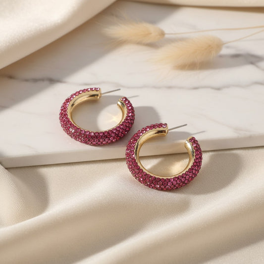 House of eLLe Party Time hoop earrings in powder pink with sparkling rhinestones on a marble and silk background.