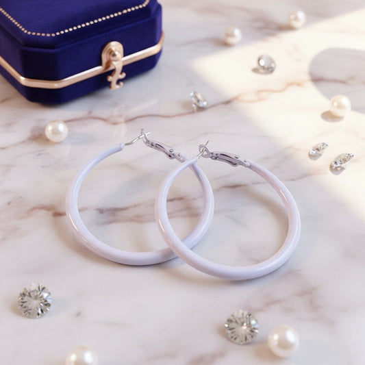 House of eLLe Springtime hoop earrings in light purple, displayed on a marble surface with pearls and a velvet box.