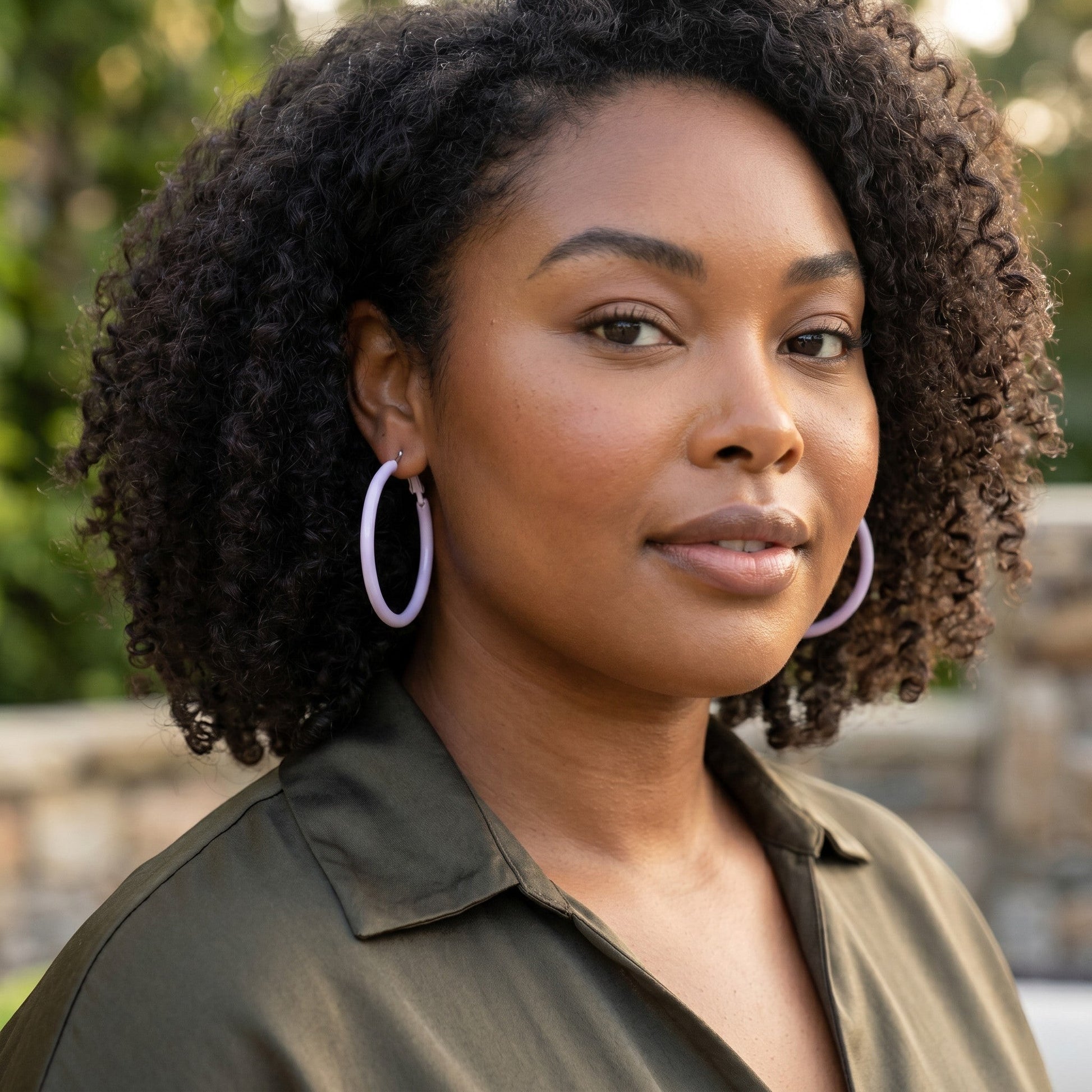 Model wearing House of eLLe Springtime purple hoop earrings in an outdoor setting