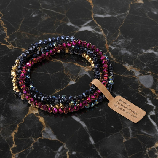 House of eLLe dark purple and silver faceted glass beaded bracelet stack on a black marble surface.