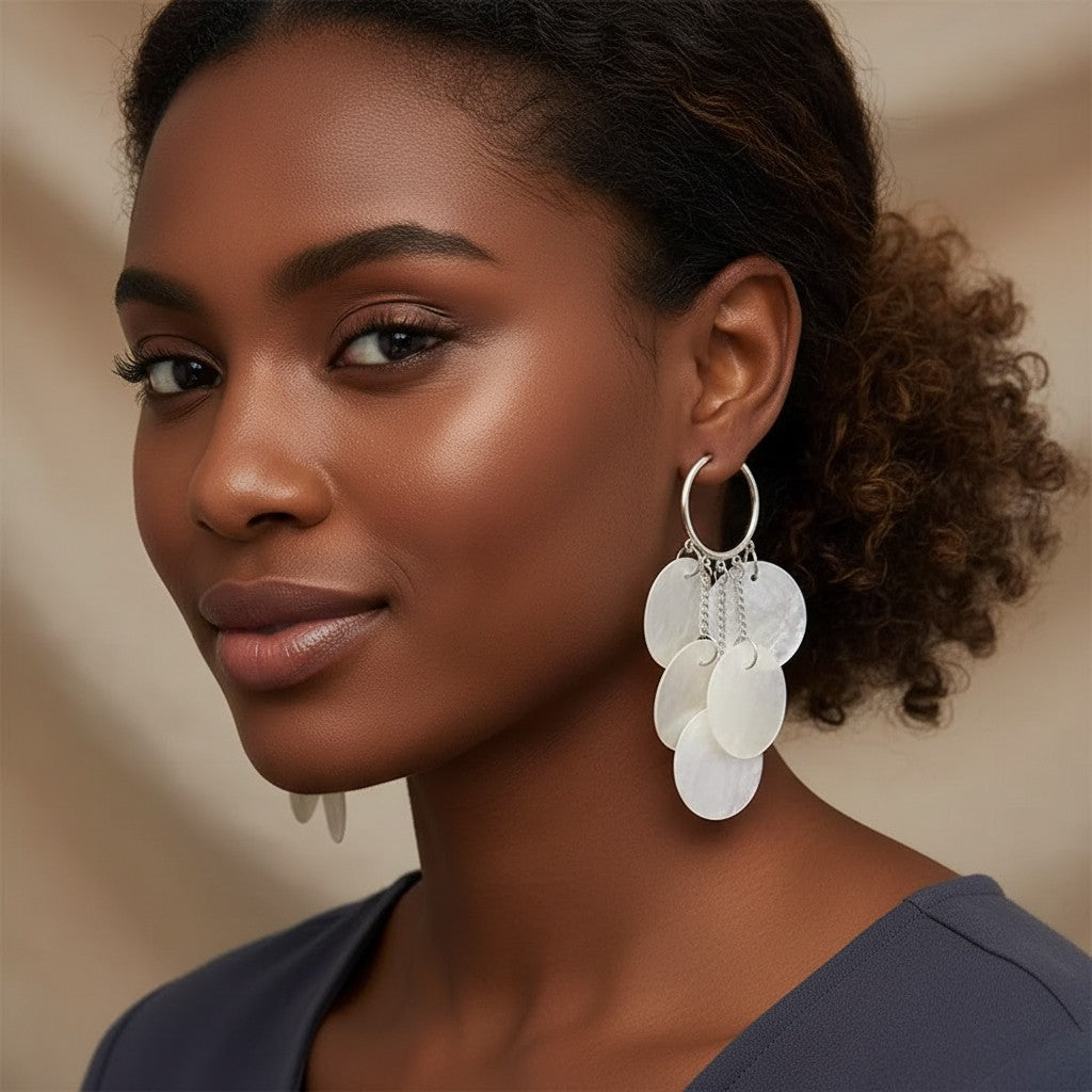 Model wearing House of eLLe Shell Life earrings featuring silver hoops with cascading white mother-of-pearl discs.