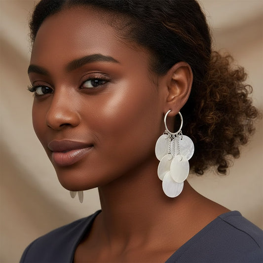Model wearing House of eLLe Shell Life earrings featuring silver hoops with cascading white mother-of-pearl discs.