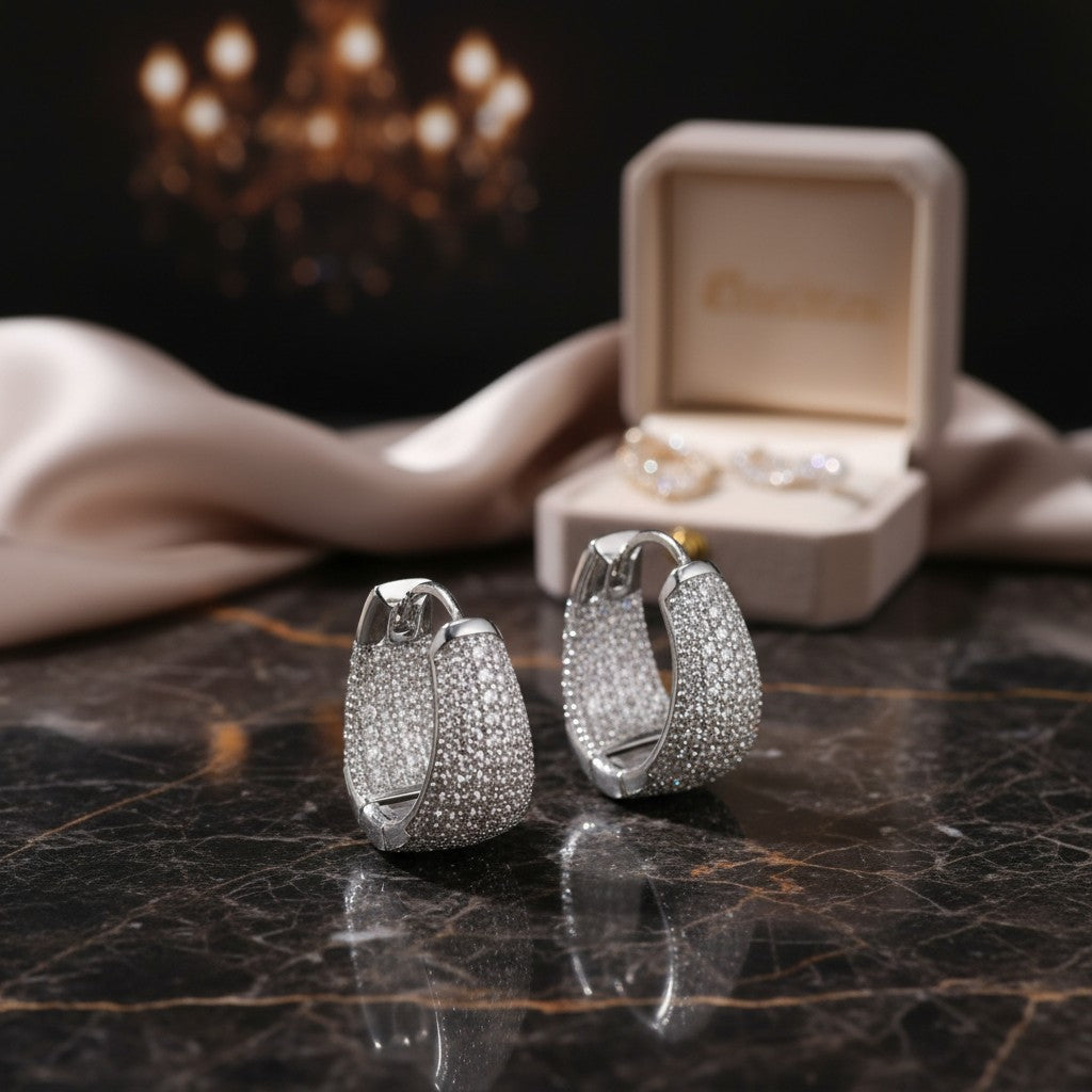House of eLLe Dipped In Bling silver hoop earrings encrusted with white diamonds on a dark marble surface.