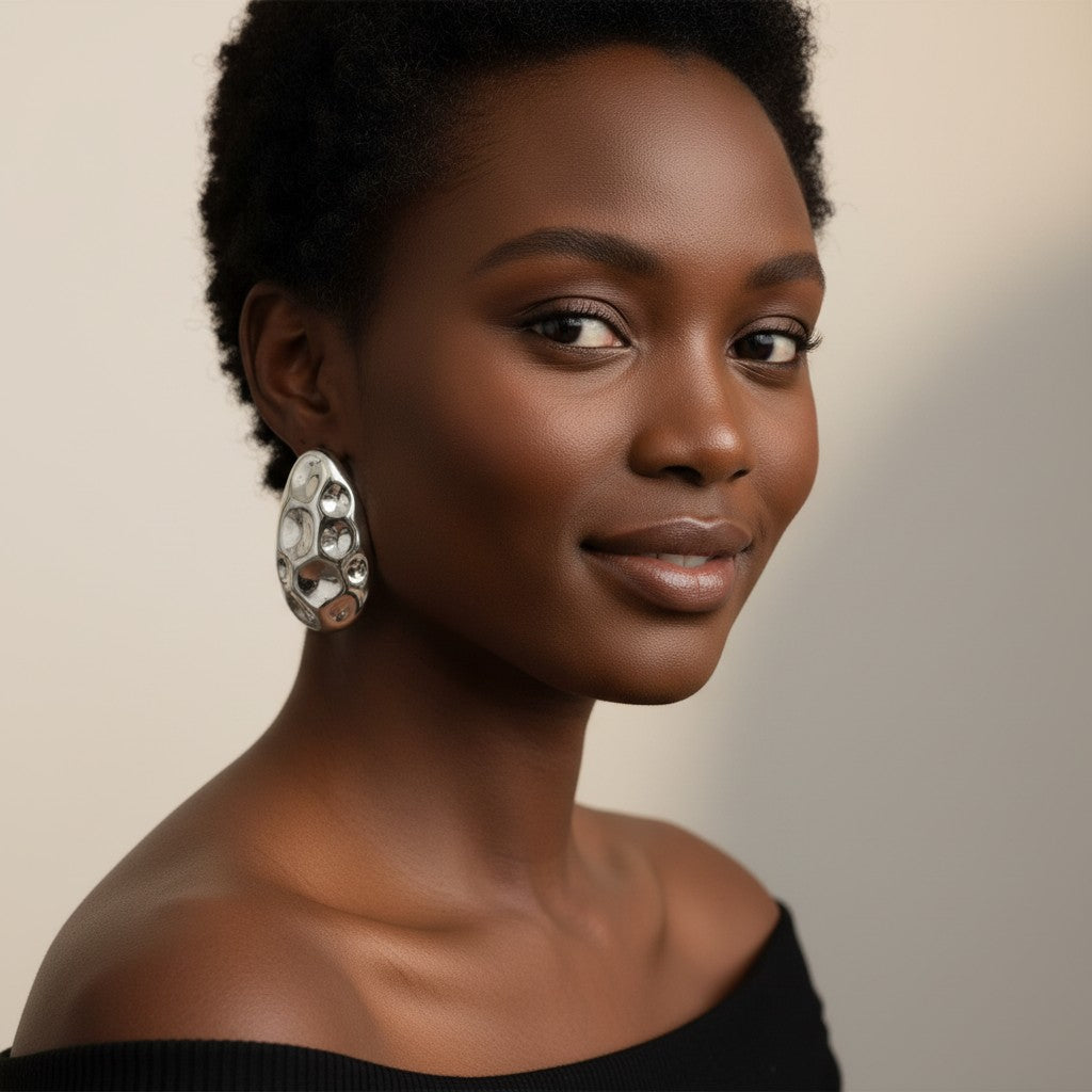 Model wearing House of eLLe A Special Affair silver earrings with a unique textured, organic pebble-like design.