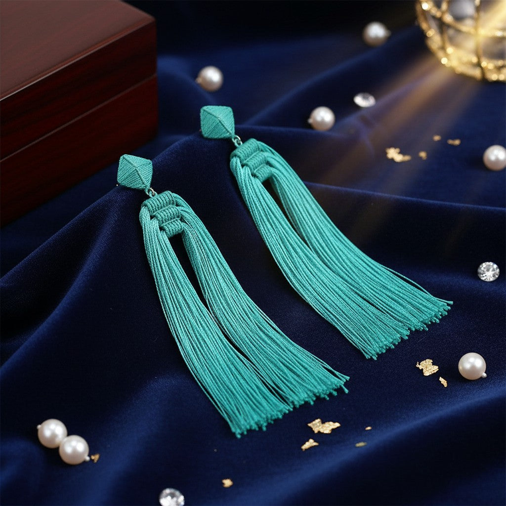 House of eLLe Queen Era sky blue tassel earrings with geometric studs on a dark blue velvet background with pearls.
